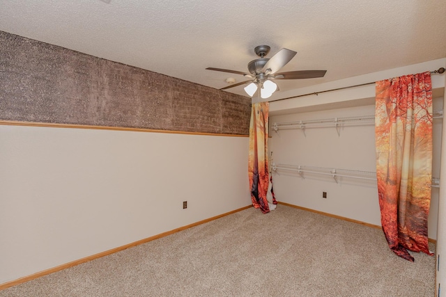 unfurnished bedroom featuring ceiling fan, a closet, a textured ceiling, and carpet flooring