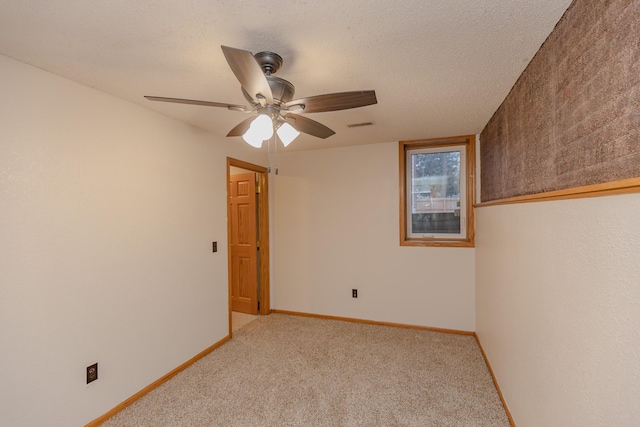 carpeted spare room with ceiling fan and a textured ceiling