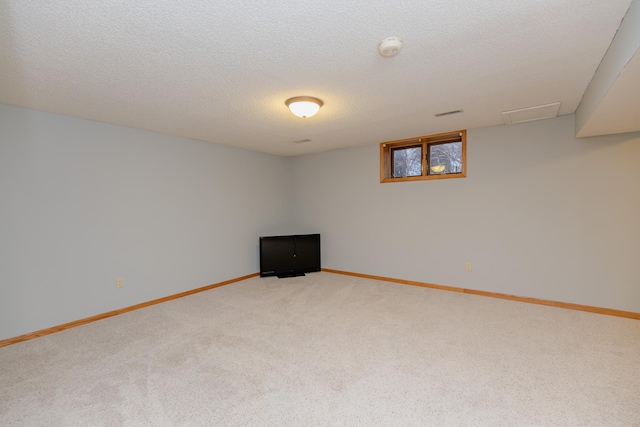 basement featuring a textured ceiling and carpet flooring