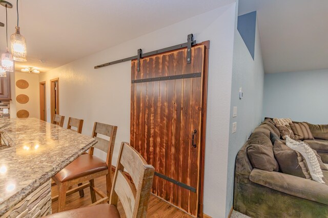 dining space with light hardwood / wood-style floors and a barn door