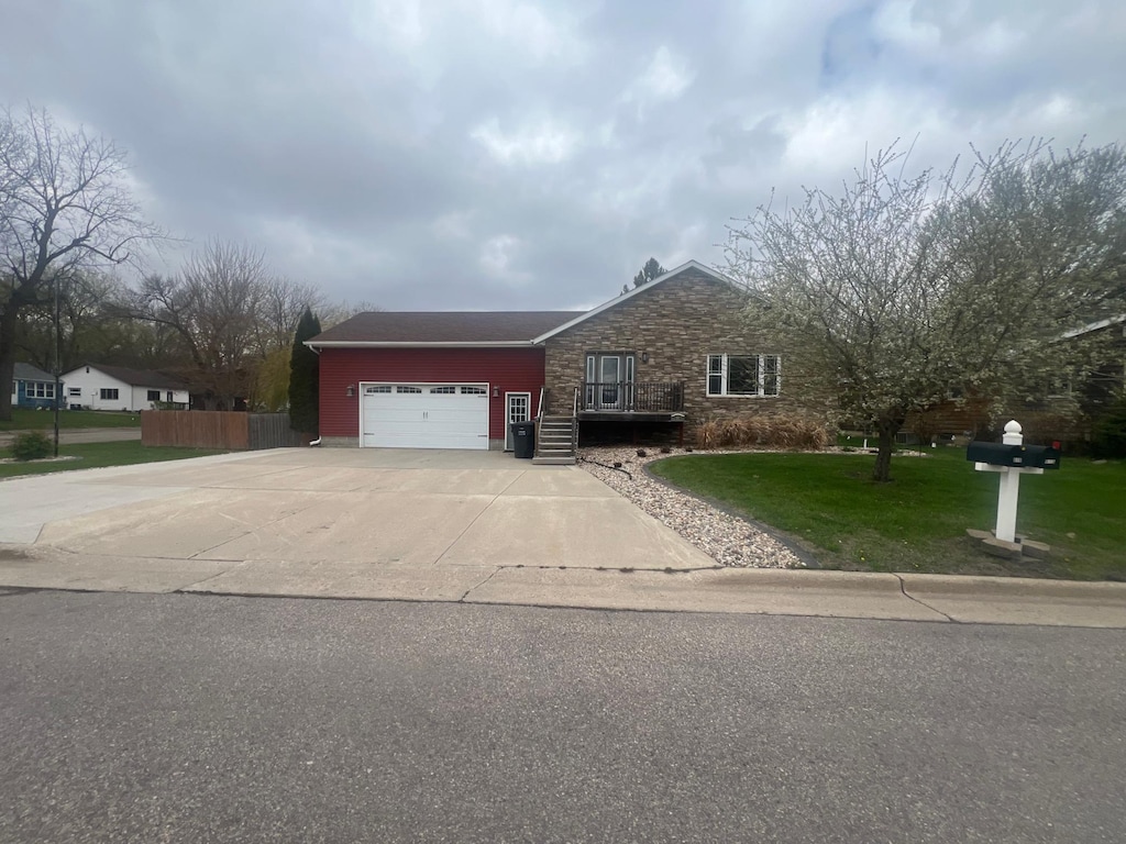 616 Betty Ave, Worthington, MN 56187 - single story home with a front lawn, fence, stone siding, an attached garage, and driveway