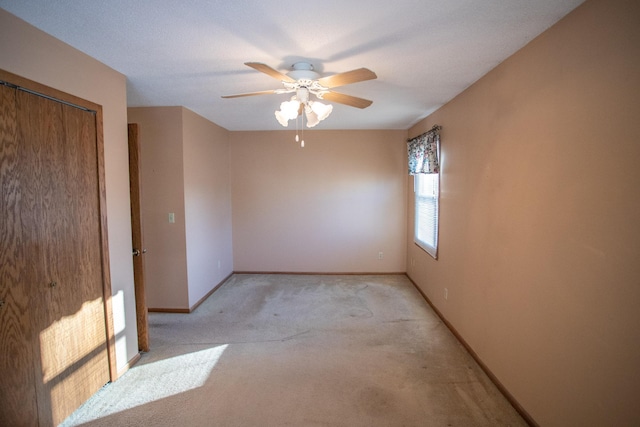 unfurnished room with ceiling fan and light colored carpet