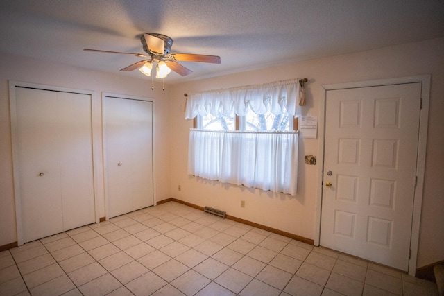 entrance foyer featuring a textured ceiling, ceiling fan, and light tile patterned floors