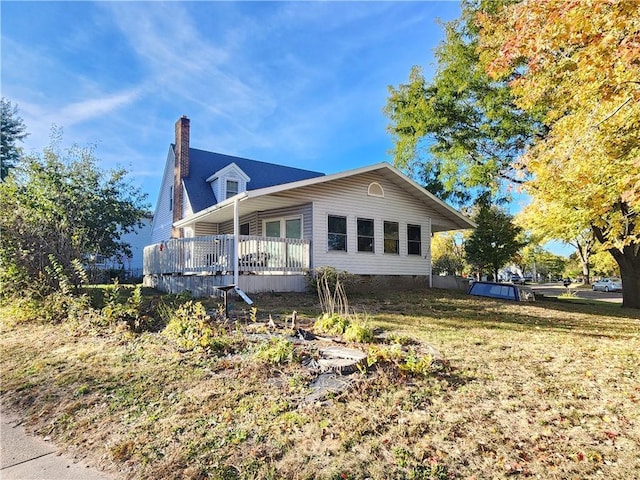 view of home's exterior featuring a lawn and a wooden deck