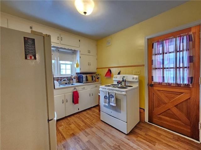 kitchen with white appliances, light wood-style flooring, light countertops, and a sink