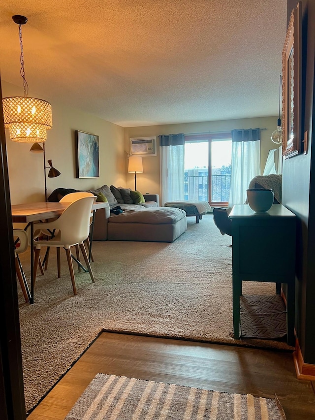 living room featuring a textured ceiling, an AC wall unit, and wood-type flooring