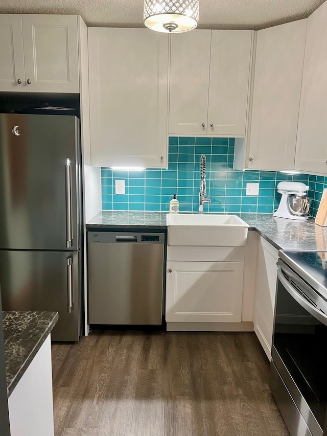 kitchen with backsplash, stainless steel appliances, white cabinets, and sink