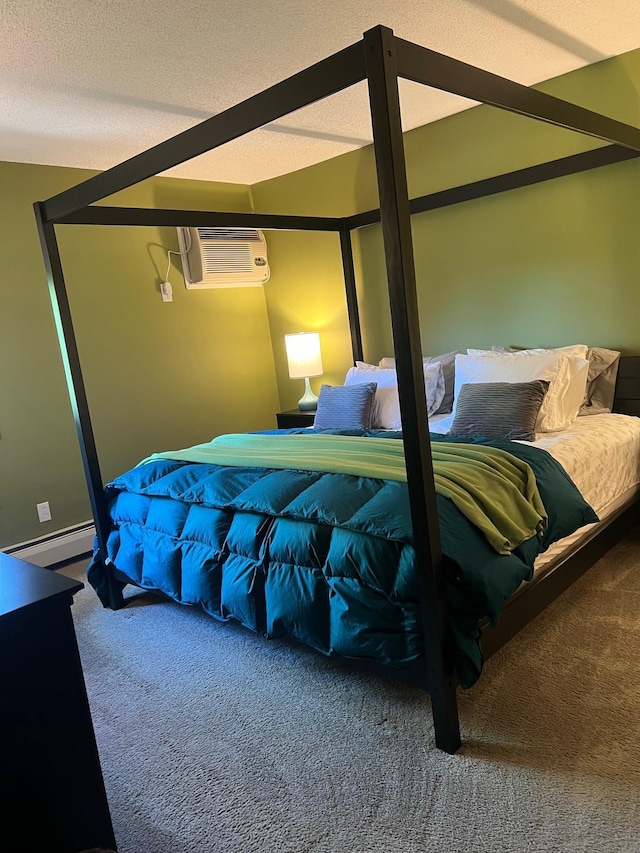 bedroom with a baseboard heating unit, carpet floors, a textured ceiling, and a wall unit AC