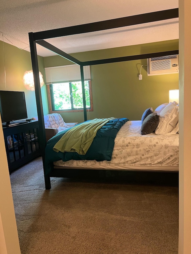 carpeted bedroom with a textured ceiling and an AC wall unit