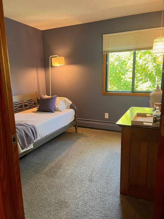 carpeted bedroom with a textured ceiling and a baseboard radiator