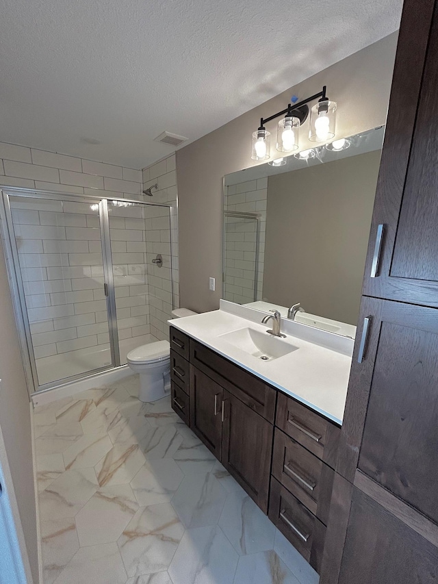 bathroom with toilet, vanity, an enclosed shower, and a textured ceiling