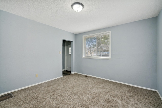 carpeted spare room featuring a textured ceiling