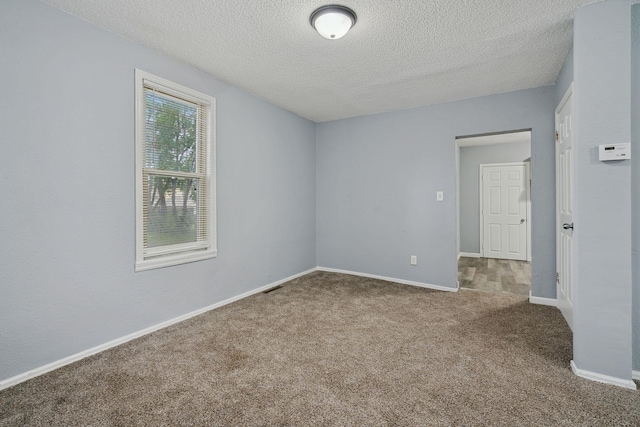 empty room featuring a textured ceiling and carpet floors