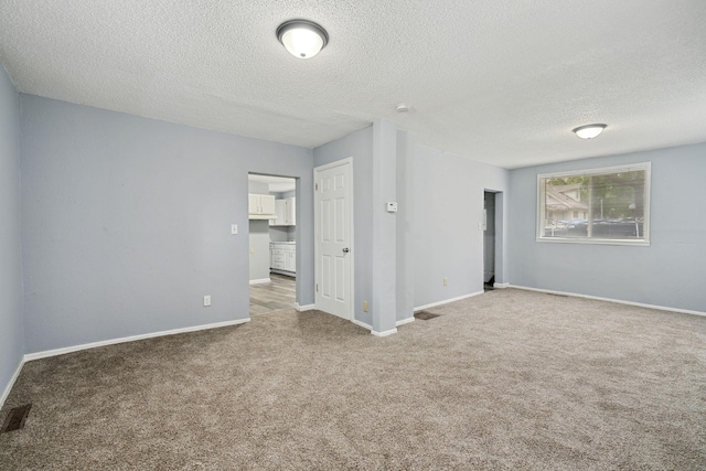 empty room with carpet flooring and a textured ceiling