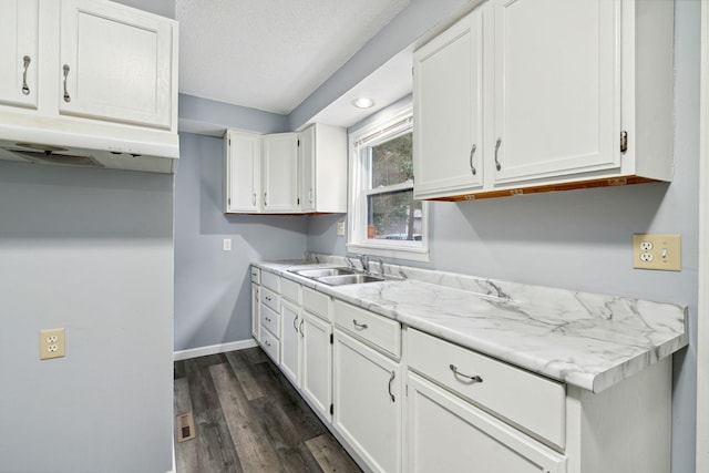 kitchen with sink, white cabinets, and light stone countertops