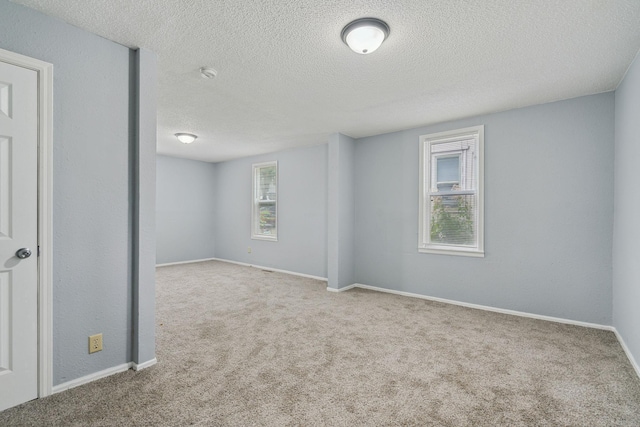 carpeted empty room with a textured ceiling