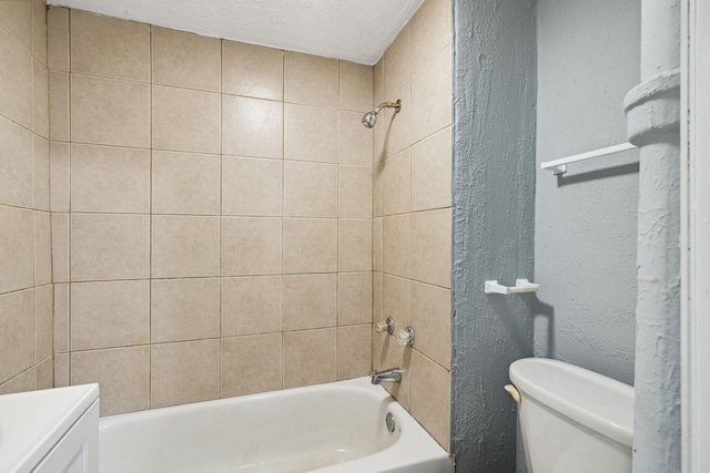 full bathroom featuring a textured ceiling, tiled shower / bath, vanity, and toilet