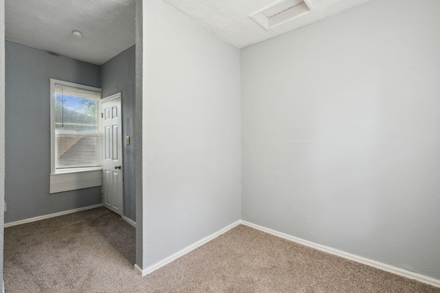 spare room with a textured ceiling and carpet