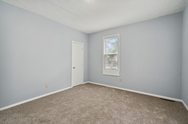 spare room with a textured ceiling and carpet