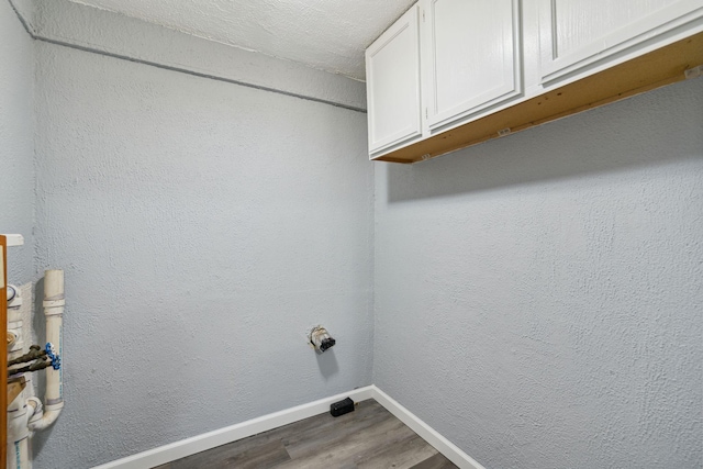 laundry room with hardwood / wood-style flooring and cabinets