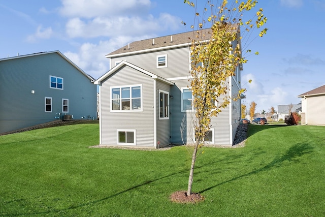 back of property with cooling unit and a lawn