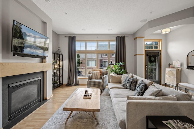 living room featuring a textured ceiling and light wood-type flooring