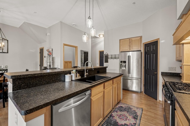 kitchen featuring stainless steel appliances, sink, an island with sink, and light wood-type flooring