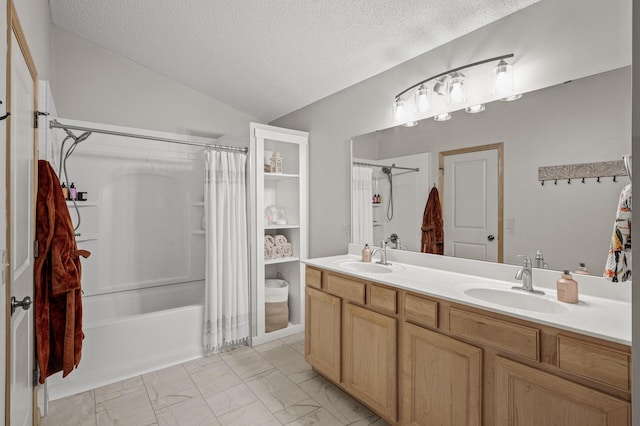 bathroom with lofted ceiling, vanity, shower / bath combo, and a textured ceiling