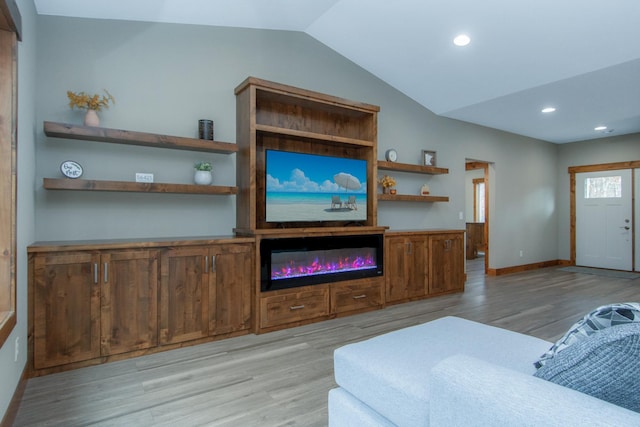 living room featuring lofted ceiling and light hardwood / wood-style floors