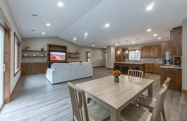 dining area with lofted ceiling and light hardwood / wood-style floors