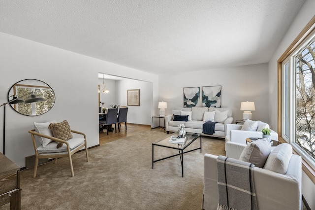 carpeted living area featuring a textured ceiling and an inviting chandelier