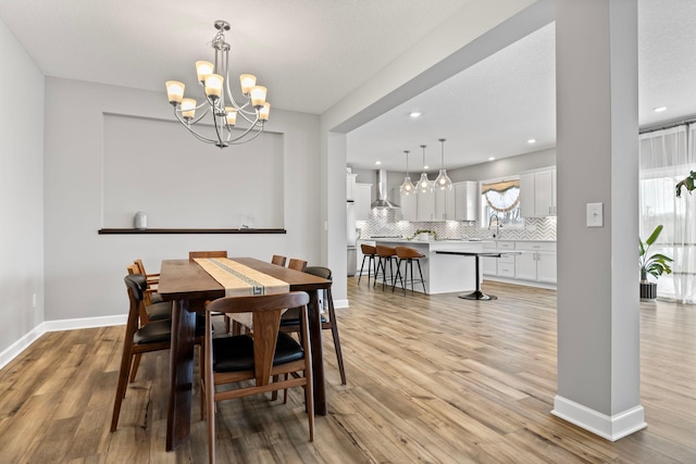 dining area featuring an inviting chandelier, light wood-type flooring, and a healthy amount of sunlight