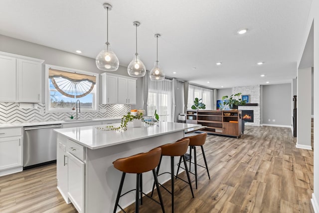 kitchen featuring white cabinets, stainless steel dishwasher, and a kitchen island