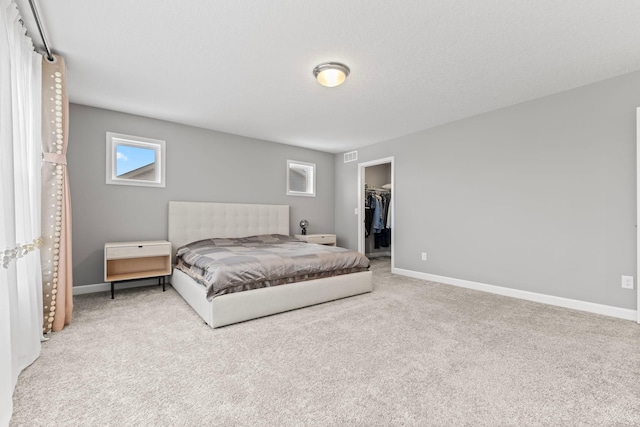 carpeted bedroom with a closet and a spacious closet