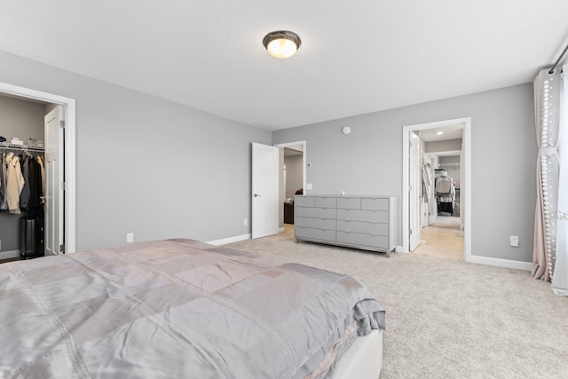 carpeted bedroom featuring a spacious closet and a closet