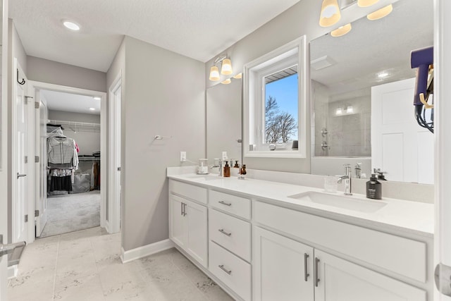 bathroom with vanity, a textured ceiling, and walk in shower