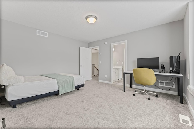 bedroom featuring ensuite bath and carpet floors