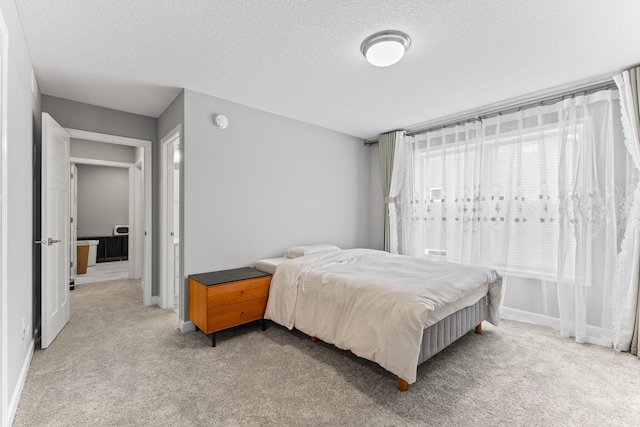 bedroom featuring a textured ceiling and light colored carpet