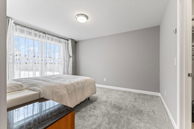 bedroom with a textured ceiling and light colored carpet