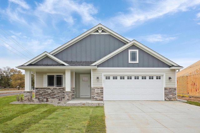 craftsman inspired home with a garage, covered porch, and a front lawn