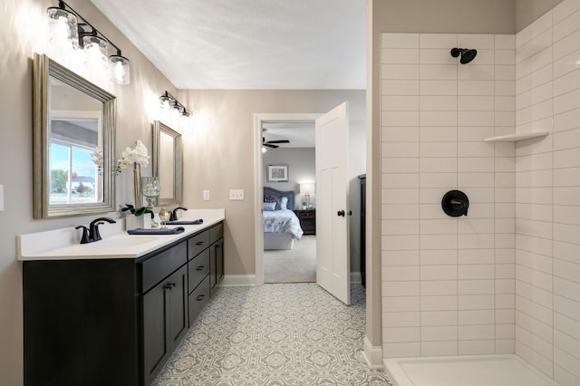 bathroom featuring ceiling fan, tiled shower, and vanity