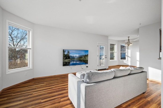 living room with a notable chandelier and dark hardwood / wood-style floors