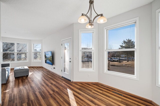 foyer entrance featuring dark wood-type flooring, a chandelier, and a textured ceiling