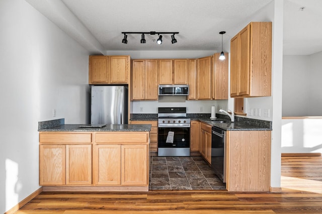 kitchen featuring hanging light fixtures, dark wood-type flooring, sink, and appliances with stainless steel finishes