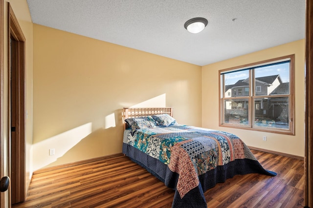 bedroom featuring dark hardwood / wood-style flooring and a textured ceiling