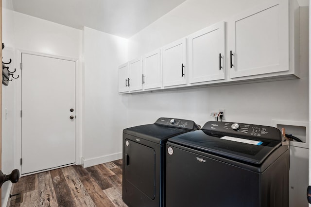 laundry room with dark hardwood / wood-style flooring, washer and clothes dryer, and cabinets