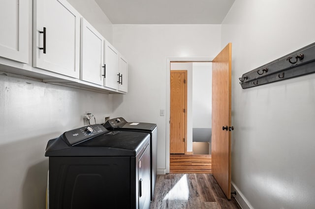 laundry room with independent washer and dryer, cabinets, and dark hardwood / wood-style floors