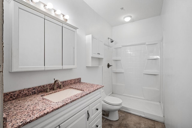 bathroom with vanity, a shower, and toilet