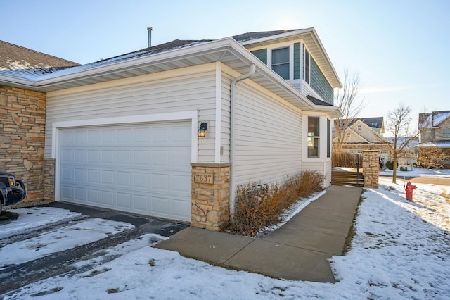 view of snow covered exterior with a garage