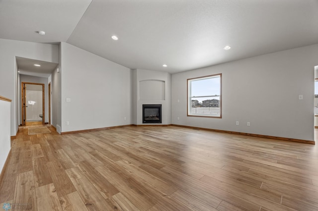 unfurnished living room with light hardwood / wood-style flooring and lofted ceiling